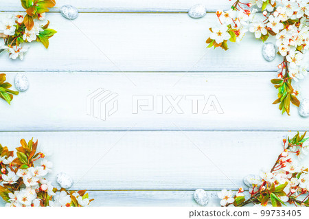 Easter eggs background. May flowers, white happy easter egg on wooden spring background. Easter card. Flat lay. Easter eggs background. May flowers, white happy easter egg on wooden spring background. Easter card. Flat lay. 99733405