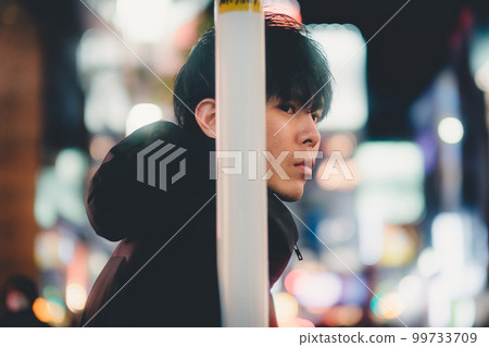 夜城中倚在桿子上的男人 99733709