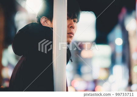 夜城中倚在桿子上的男人 99733711