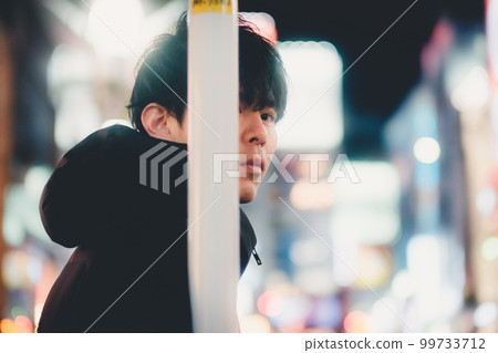 夜城中倚在桿子上的男人 99733712