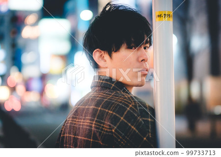 夜城中倚在桿子上的男人 99733713