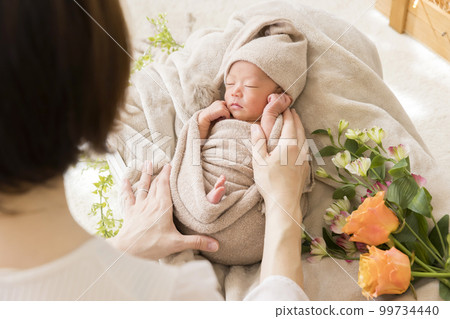 Mother and baby preparing for newborn photo shoot 99734440