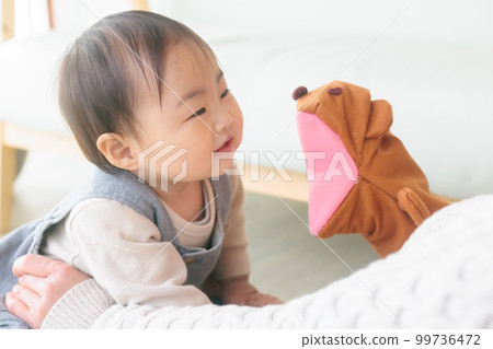 Home daycare baby fascinated by hand puppets talking play 99736472