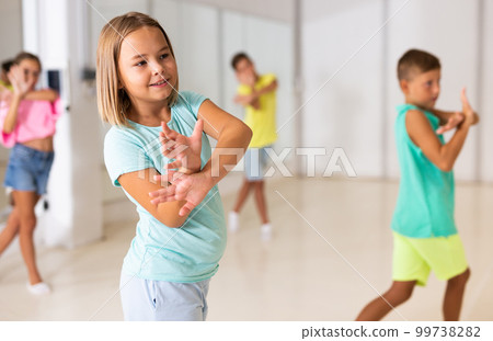 Young girls and boys performing modern dance in studio Young girls and boys performing modern dance in studio 99738282