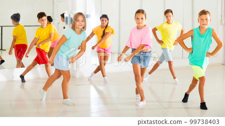 Young girls and boys performing modern dance in studio Young girls and boys performing modern dance in studio 99738403
