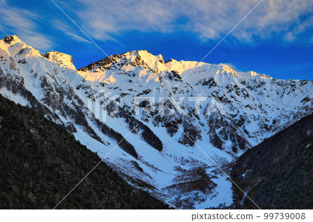 The snow-capped Hotaka mountain range in the morning glow seen from Kamikochi's Kappa Bridge 99739008