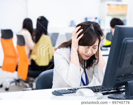 女商人在做案頭工作時抱著頭 女商人在做案頭工作時抱著頭 99740776