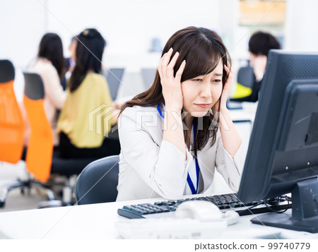 女商人在做案頭工作時抱著頭 女商人在做案頭工作時抱著頭 99740779