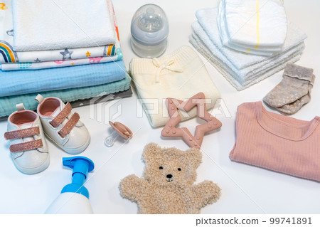 Concept of giving birth. Set of clothes and accessories for newborn on white background 99741891
