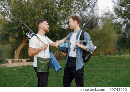 Friends is ready to fishing. Men holding a fishing equipment. One man wearing rose t-shirt and other blue shirt. 99743010