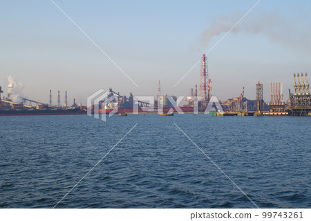 A view of a cargo ship and a steel mill loading and unloading in the Mizushima Rinkai Industrial Area A view of a cargo ship and a steel mill loading and unloading in the Mizushima Rinkai Industrial Area 99743261
