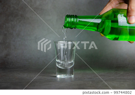 soju is pouring on glass, selective focus 99744802