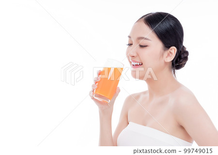 Portrait of Beautiful young woman holding orange juicy and smile isolated on white background. 99749015