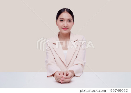 Young businesswoman in a cream suit. Isolate on a pastel yellow background. 99749032
