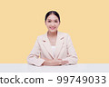 Young businesswoman in a cream suit. Isolate on a pastel yellow background. 99749033