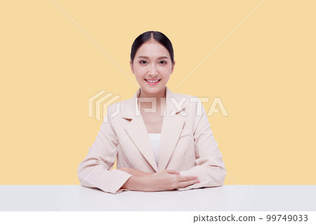 Young businesswoman in a cream suit. Isolate on a pastel yellow background. 99749033
