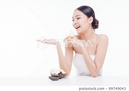 Beauty woman perfect face fresh clean skin portrait isolated on white. Beautiful asian girl holding plumeria flowers with make up and beauty healthy skin color lips red and hair portrait. Spa and skin Beauty woman perfect face fresh clean skin portrait isolated on white. Beautiful asian girl holding plumeria flowers with make up and beauty healthy skin color lips red and hair portrait. Spa and skin 99749043