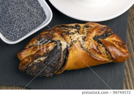 Fresh bun with poppy seed filling on the table 99749572