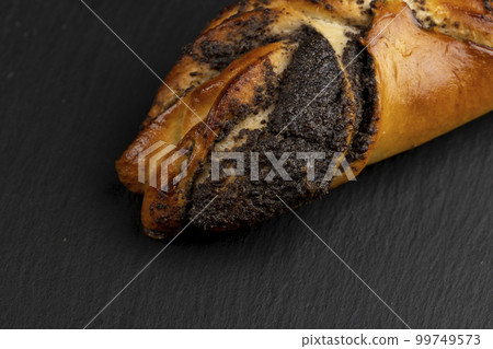 Fresh bun with poppy seed filling on the table 99749573