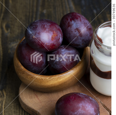 Ripe delicious plums of dark color 99749636