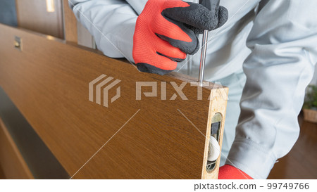 Image of a worker repairing and inspecting a sliding door roller Image of a worker repairing and inspecting a sliding door roller 99749766