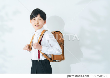 A boy carrying a school bag 99750322