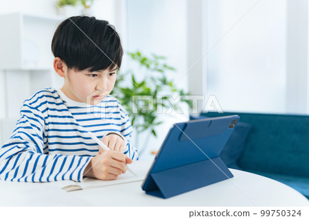 一個男孩邊看平板邊學習 99750324