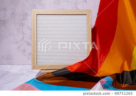 Empty blank frame on Rainbow LGBTQIA flag made from silk material with copy space for your text. Mock up template. Symbol of LGBTQ pride month. Equal rights. Peace and freedom. Support LGBTQIA 99751265