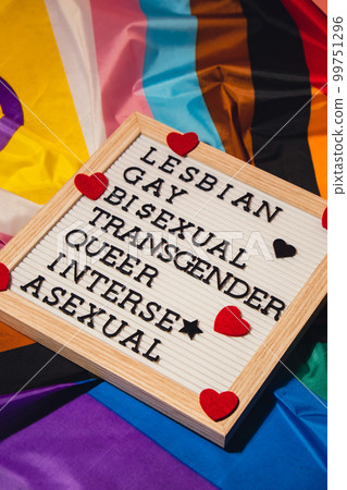 LGBTQIA description frame on Rainbow LGBTQIA flag made from silk material. LESBIAN, GAY, BISEXUAL, TRANSGENDER, QUEER, INTERSEX, ASEXUAL Symbol of LGBTQ pride month. Equal rights. Peace and freedom LGBTQIA description frame on Rainbow LGBTQIA flag made from silk material. LESBIAN, GAY, BISEXUAL, TRANSGENDER, QUEER, INTERSEX, ASEXUAL Symbol of LGBTQ pride month. Equal rights. Peace and freedom 99751296