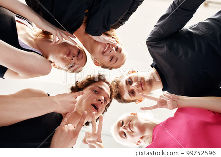 Team of people holding hands. Group of happy young women holding hands. Bottom view, low angle shot of human hands. Friendship and unity concept 99752596