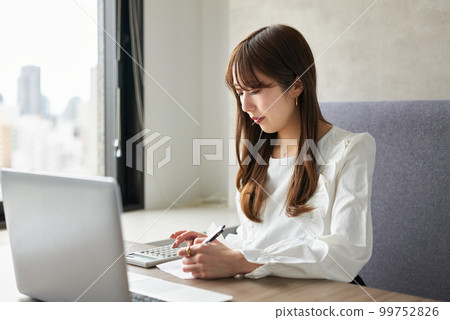 A woman filing a tax return on a laptop 99752826