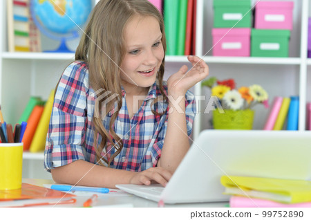girl using laptop at desk at home girl using laptop at desk at home 99752890