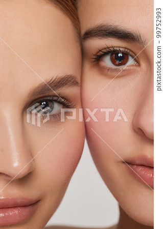 Vertical cropped portrait of young beautiful female couple. Models with well-kept skin and nude makeup. Concept of emotions, beauty, vision, health and fashion 99752993
