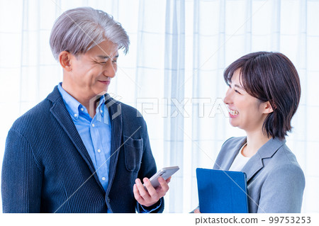 A middle male boss and a young female subordinate who talk while standing A middle male boss and a young female subordinate who talk while standing 99753253