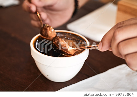 Barista preparing to test and inspecting the quality of coffee Barista preparing to test and inspecting the quality of coffee 99753804