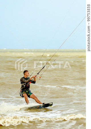Young Man KiteBoarding on the waves Extreme Sport Kitesurfing Young Man KiteBoarding on the waves Extreme Sport Kitesurfing 99753838
