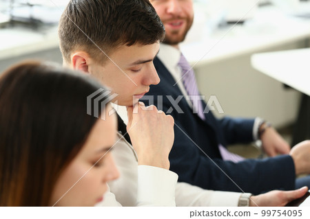 Portrait of confident people seriously looking at business papers during work meeting Portrait of confident people seriously looking at business papers during work meeting 99754095