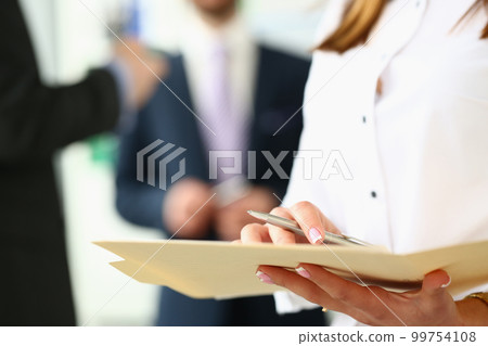 Women hands holding pen and documents in background business people Women hands holding pen and documents in background business people 99754108