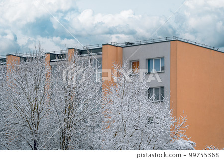 Winter landscape of frosty trees and multi story house Winter landscape of frosty trees and multi story house 99755368