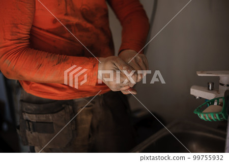 The mechanic washes his hands after car repair. Worker washes his hands 99755932