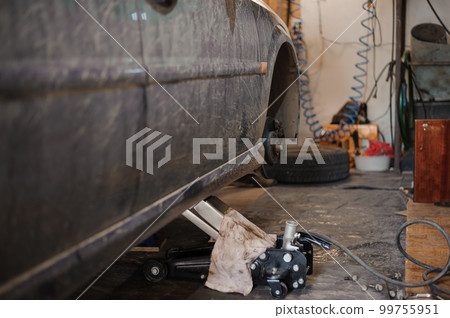 Car brake part in the garage, car brake disc without wheels. Car suspension. Current car repair Car brake part in the garage, car brake disc without wheels. Car suspension. Current car repair 99755951