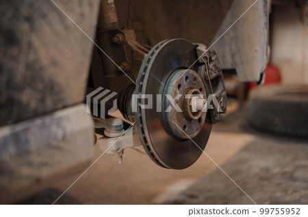 Car brake part in the garage, car brake disc without wheels. Car suspension. Current car repair 99755952