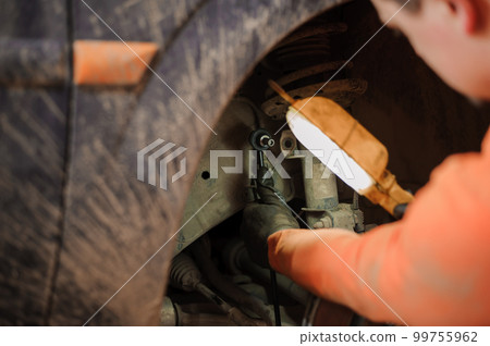 Replacement and repair of wheels and shock absorbers on a car in a garage 99755962