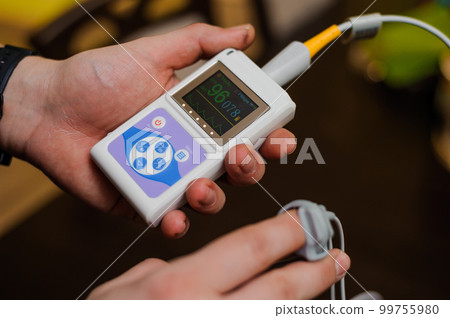 Man using pulse oximeter measures oxygen saturation level, health care monitoring concept. Pulse oximeter on brown background Man using pulse oximeter measures oxygen saturation level, health care monitoring concept. Pulse oximeter on brown background 99755980