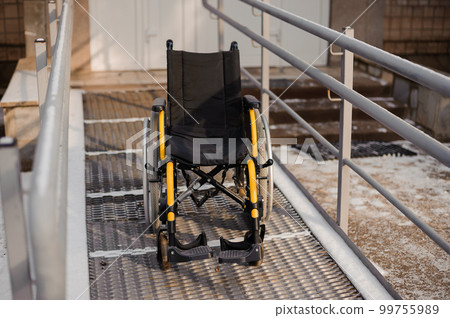 Empty wheelchair in the hospital on the ramp. Wheelchair close-up. Children's wheelchair 99755989
