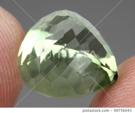 Natural gemstone green prasiolite amethyst on gray background 99756043