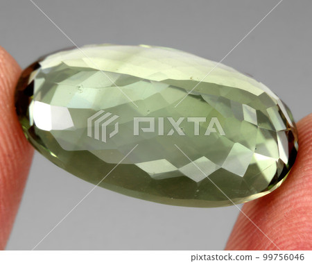 Natural gemstone green prasiolite amethyst on gray background 99756046