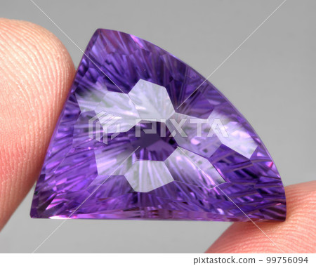 Natural gemstone purple amethyst on gray background 99756094