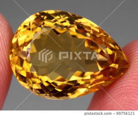 Natural gemstone yellow citrine on gray background 99756121