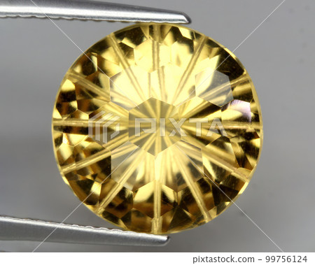 Natural gemstone yellow citrine on gray background 99756124